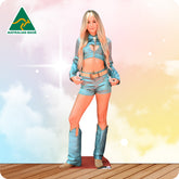 Cardboard cutout of a person wearing a blue outfit with boots on a wooden floor and colorful background.